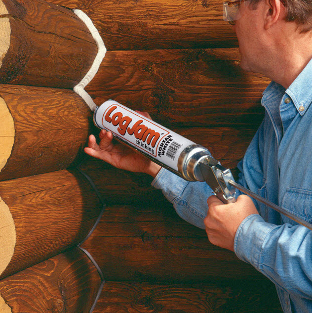 man using log jam chinking canada